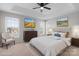 Staged bedroom boasts a cozy bed, dresser with artwork, and plenty of natural light from the large windows at 9413 Pastern Ct, Charlotte, NC 28216