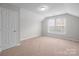 Unfurnished bedroom offers neutral carpeting, ample natural light from windows, and a spacious closet at 9413 Pastern Ct, Charlotte, NC 28216