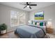 Staged bedroom with sloped ceilings features a cozy bed and lots of natural light from the double windows at 9413 Pastern Ct, Charlotte, NC 28216