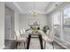 Elegant dining room with a glass-top table, plush rug, modern chandelier, and ample natural light at 9413 Pastern Ct, Charlotte, NC 28216