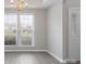 Bright living area with large windows, neutral walls, a modern light fixture and hardwood floors at 9413 Pastern Ct, Charlotte, NC 28216