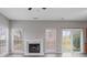 Bright living room featuring a fireplace, hardwood floors, multiple windows, and a sliding glass door at 9413 Pastern Ct, Charlotte, NC 28216