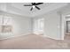 Bright main bedroom featuring a ceiling fan, neutral walls, carpet and an ensuite bath at 9413 Pastern Ct, Charlotte, NC 28216