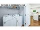 Functional laundry room with washer, dryer, and shelving for storage at 104 Woodhall Way, Troutman, NC 28166