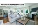 Open concept living area featuring a modern kitchen, fireplace, and plenty of natural light at 104 Woodhall Way, Troutman, NC 28166