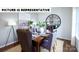 Elegant dining room with a wooden table, upholstered chairs, modern lighting, and a large decorative clock on the wall at 120 Woodhall Way, Troutman, NC 28166