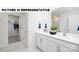 Bright bathroom showcasing a double vanity with white cabinets, modern fixtures, and closet at 122 Woodhall Way, Troutman, NC 28166