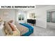Stylish bedroom featuring a patterned bedspread, dresser with gold mirror, and neutral walls at 122 Woodhall Way, Troutman, NC 28166