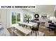 Open dining area includes a long wooden table, black chairs, and sliding glass doors to the backyard at 122 Woodhall Way, Troutman, NC 28166