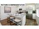 Modern kitchen with stainless steel appliances, granite counters, breakfast bar with seating, and ample natural light at 122 Woodhall Way, Troutman, NC 28166