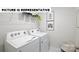 Well-lit laundry room with modern, front-load washer and dryer at 122 Woodhall Way, Troutman, NC 28166