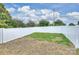 A fenced backyard featuring green and dormant grass under a partially cloudy sky at 12243 Monteith Grove Dr, Huntersville, NC 28078