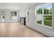 Bright living area with hardwood floors, a modern fireplace, and large windows overlooking the yard at 12243 Monteith Grove Dr, Huntersville, NC 28078