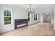 Bright living room featuring a modern fireplace, wood floors, and stylish chandelier at 12243 Monteith Grove Dr, Huntersville, NC 28078