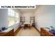 A well-lit office featuring a large window, stylish chairs, and wooden shelving units for storage at 126 Woodhall Way, Troutman, NC 28166