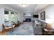 Comfortable living room with a fireplace and large windows offering plenty of natural light at 1301 Old Pond Ln, Matthews, NC 28105