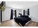 Relaxing bedroom features wood floors, large windows, and stylish decor at 1304 Browdis Ave, Kannapolis, NC 28083