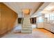 Basement staircase leading to an unfinished area with a fireplace and kitchenette at 1330 College Ave, Shelby, NC 28152