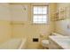 Bathroom featuring tiled walls, bathtub, a toilet, and a window at 1330 College Ave, Shelby, NC 28152