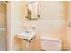 Cozy half bathroom features a tiled wall, toilet, and sink at 1330 College Ave, Shelby, NC 28152
