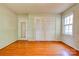 Bedroom featuring hardwood flooring, a window, a closet, and a door with a mirror at 1330 College Ave, Shelby, NC 28152