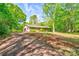 A charming brick home with an attached garage nestled among mature trees and lush greenery at 1330 College Ave, Shelby, NC 28152