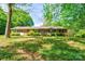 Charming brick home featuring green shutters, lush landscaping, and a sprawling lawn at 1330 College Ave, Shelby, NC 28152