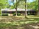 Charming single-story brick home featuring a well-manicured lawn and mature trees providing ample shade at 1330 College Ave, Shelby, NC 28152