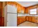 Kitchen showcasing wood cabinets, white appliances, and a window above the sink at 1330 College Ave, Shelby, NC 28152