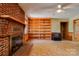 Living room with brick fireplace, built-in shelving, and a vintage television at 1330 College Ave, Shelby, NC 28152