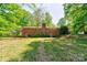 A brick home featuring a chimney and a spacious yard perfect for outdoor activities at 1330 College Ave, Shelby, NC 28152