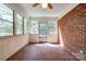 Enclosed sunroom with brick accent wall, tile floor, and multiple windows at 1330 College Ave, Shelby, NC 28152
