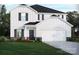Charming two-story home featuring white siding, a stone foundation, a two-car garage, and a well-manicured lawn at 1414 Windy Park Dr, Stanley, NC 28164