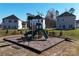Community playground with multiple slides and benches sitting on a bed of wood chips and well manicured lawn at 1414 Windy Park Dr, Stanley, NC 28164