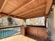 Covered outdoor kitchen with wood ceiling, bar, and view of the pool and backyard at 1589 E Lakewood Dr, Rock Hill, SC 29732