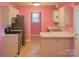 A kitchen with a refrigerator, oven, sink, white cabinets and pink walls at 1660 Ashridge Rd, Rock Hill, SC 29730