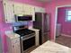 This kitchen features stainless steel appliances, bright pink walls, and white cabinets and countertops at 1660 Ashridge Rd, Rock Hill, SC 29730