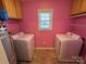 This laundry room features dual washing machines, pink walls and a window at 1660 Ashridge Rd, Rock Hill, SC 29730