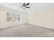 Spacious bedroom with neutral carpet, ceiling fan, and a large window at 171 Longboat Rd, Mooresville, NC 28117