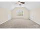 Large bonus room featuring carpeted floors, a vaulted ceiling, and a central window at 171 Longboat Rd, Mooresville, NC 28117