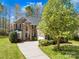 Charming brick two-story home with a well-manicured lawn and a long driveway leading up to the garage at 171 Longboat Rd, Mooresville, NC 28117