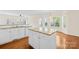 Kitchen boasts granite countertops, white cabinetry, stainless steel sink, and views of an adjacent eat-in area at 171 Longboat Rd, Mooresville, NC 28117