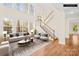 Bright, staged living room with high ceilings, large windows, and a staircase to the second floor at 171 Longboat Rd, Mooresville, NC 28117