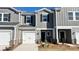 Charming two-story townhouse featuring a one-car garage, gray siding, and brick accents for added curb appeal at 1748 Braemar Village Dr, Monroe, NC 28110