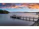 Beautiful sunset view of the lake featuring a private dock with boat lift at 18201 Town Harbour Rd, Cornelius, NC 28031