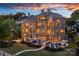 Stunning three-story home featuring an outdoor pool, manicured landscaping, and a serene twilight ambiance at 18201 Town Harbour Rd, Cornelius, NC 28031