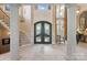 Elegant foyer with soaring ceilings, a grand staircase, and decorative iron doors at 18201 Town Harbour Rd, Cornelius, NC 28031