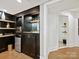 Stylish wet bar with dark cabinetry, granite countertops, and a mini-fridge, perfect for entertaining at 19000 Hodestone Mews Ct, Davidson, NC 28036