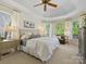 Bright bedroom features a tray ceiling, neutral decor, and large windows at 19000 Hodestone Mews Ct, Davidson, NC 28036