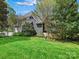 Beautiful home exterior showcasing lush green lawn and mature landscaping with abundant greenery and blue skies at 19000 Hodestone Mews Ct, Davidson, NC 28036